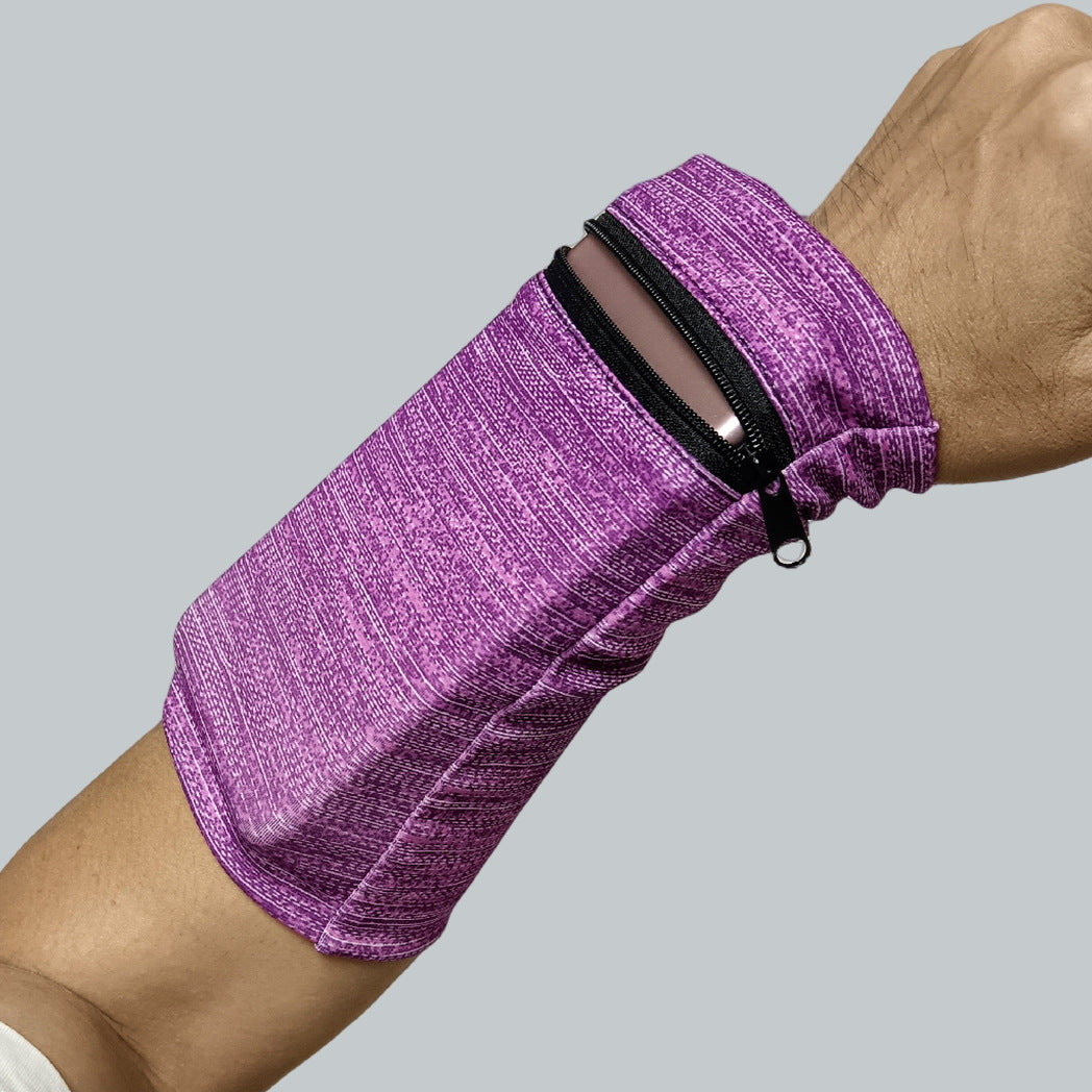 En person bär ett lila Sportarmband med Dragkedja från Elevkassan, där en smartphone förvaras i fickan, mot en enkel grå bakgrund.