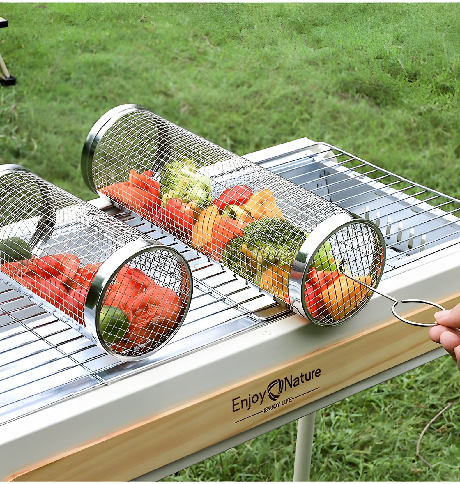 Två Grillbur i Rostfritt Stål - 2-pack från Elevkassan, fyllda med hackade grönsaker och kött, är placerade på en metallgrill över ett träbord utomhus, med gräs synligt i bakgrunden.