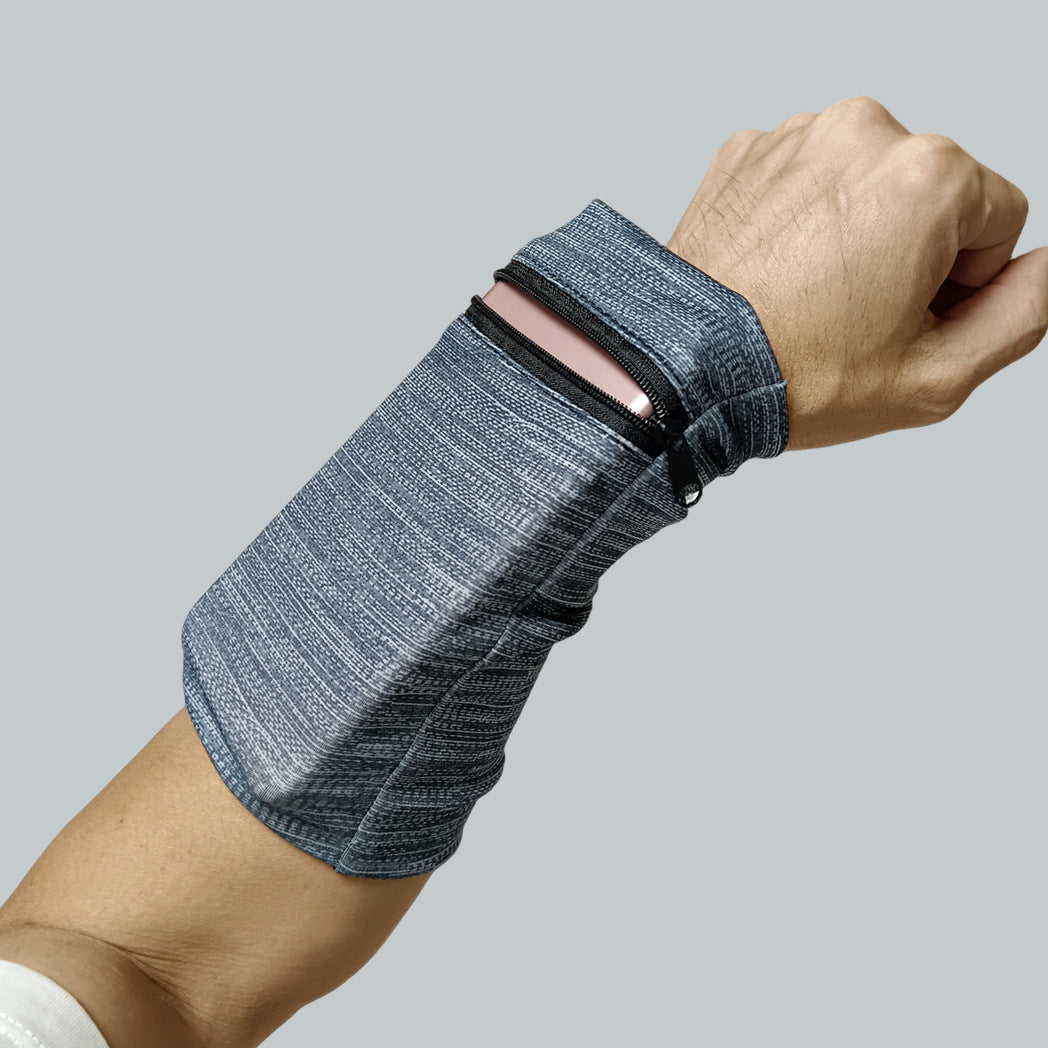 En hand och en underarm bär Elevkassan Sportarmband med Dragkedja, vars blixtlåsförsedda ficka är delvis öppen för att visa en smartphone inuti. Perfekt för löpning, visas mot en enfärgad ljusgrå bakgrund.